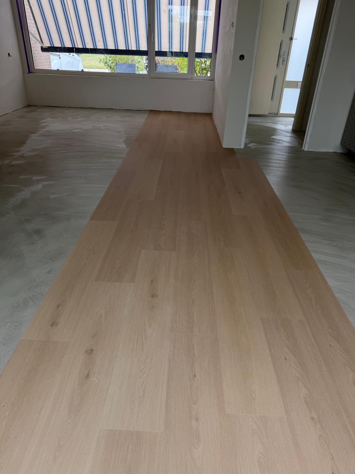 Straight-plank PVC half laid on levelling compound