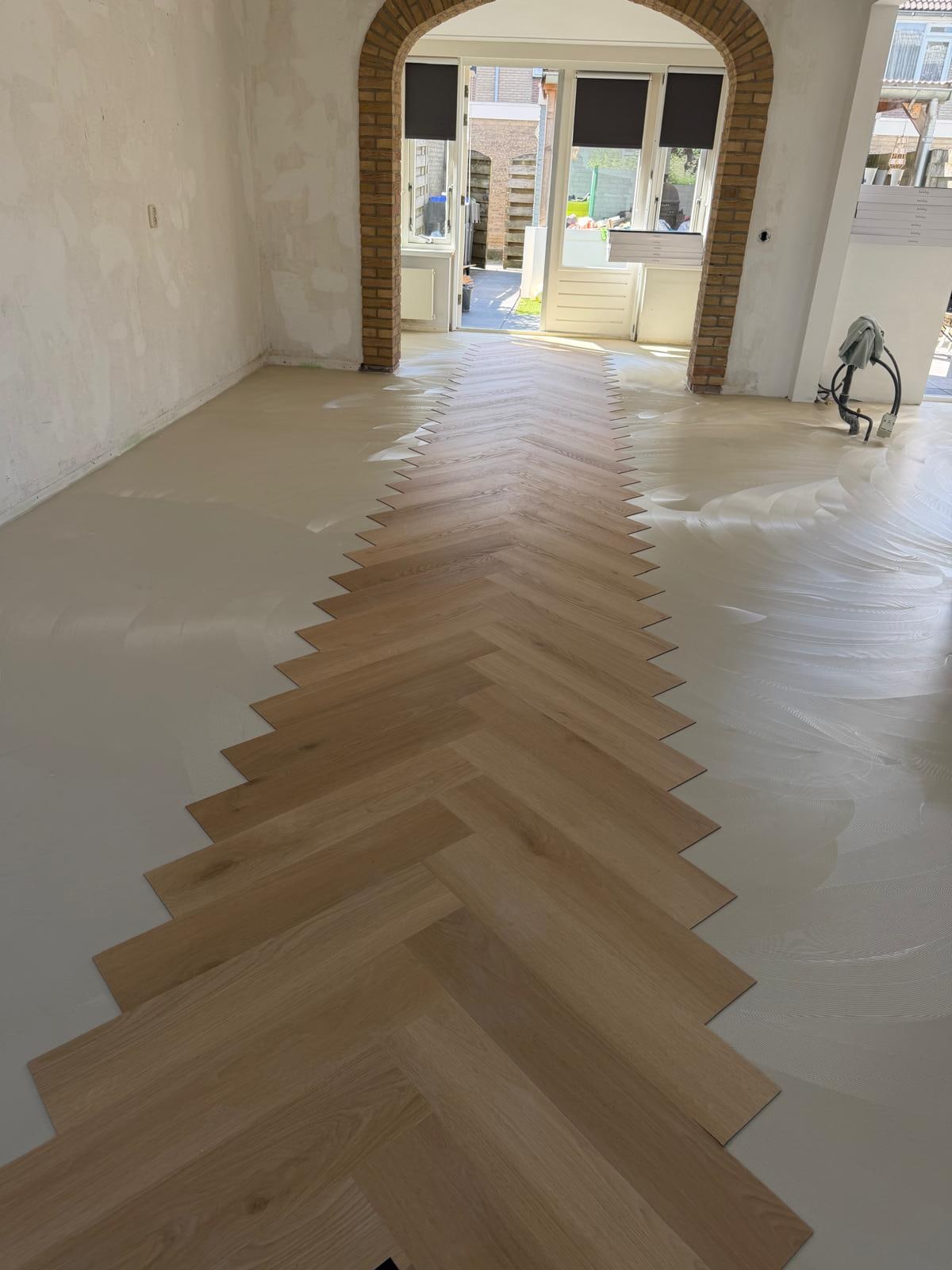 Herringbone PVC being laid on fresh levelling compound